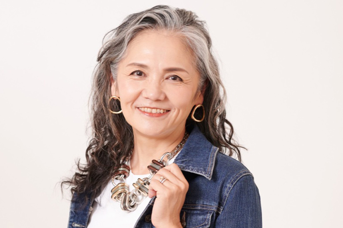 自然な白髪を含むウェーブヘアを楽しむ女性の写真